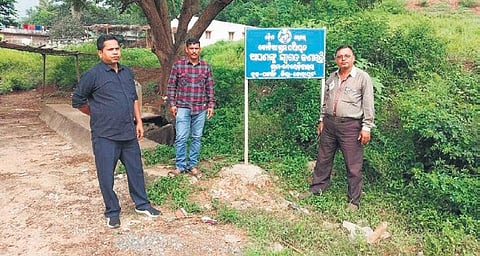 Koraput officials near the new signboard of Odisha government in Neradivalsa. (Photo | Express)