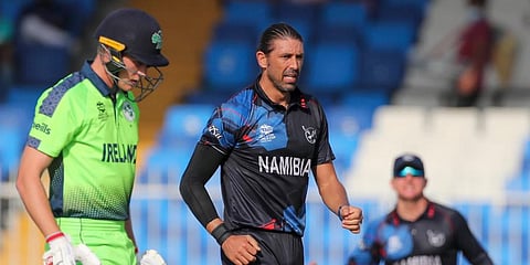 Namibia's David Wiese, centre, celebrates after taking the wicket of Ireland's Harry Tector, left, during their ICC men's T20 World Cup first round match in Sharjah, UAE. (Photo | PTI)