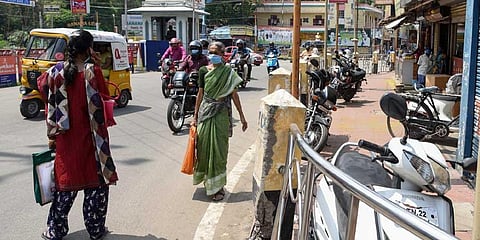 Shopkeepers encroaching the pedestrian path at Main Guard Gate in Tiruchy on Thursday. (MK Ashok Kumar | EPS)