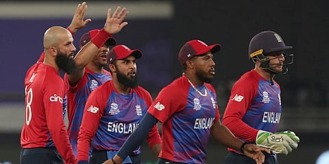 England's Moeen Ali (L) celebrates with teammates after taking the wicket of West Indies' Lendl Simmons during the T20 World Cup match at the Dubai International Cricket Stadium in Dubai. (Photo | AP)