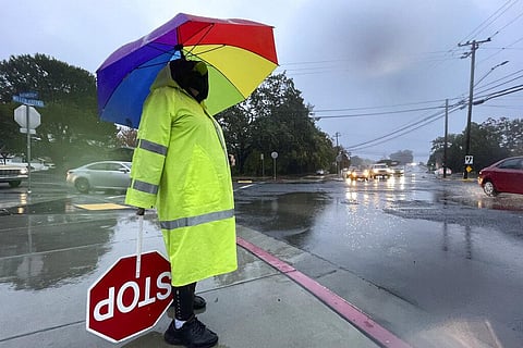 Crossing guard Katy Bredahl is pelted with rain while keeping an eye out for children on Marinwood Avenue in San Rafael, Calif. (Photo | AP)