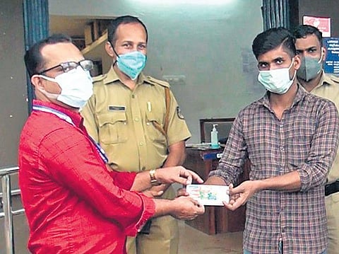 Imam Hussein hands over his winning ticket to P Sreenivasan, Allanallur Service Co-operative Bank secretary, at the Nattukal police station | Express