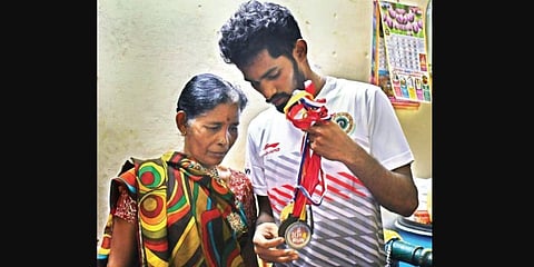 K Pydappadu shows his mother Narayanamma the medals won during several State-level running competitions. (Photo | Prasant Madugula, EPS)