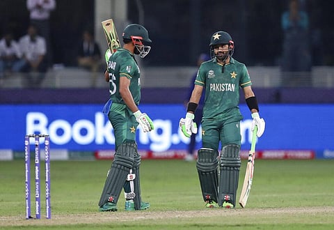 Pakistan captain Babar Azam celebrates after scoring halfcentury, watched by Mohammad Rizwan during the ICC World T20 match between India and Pakistan. (Photo | AP)