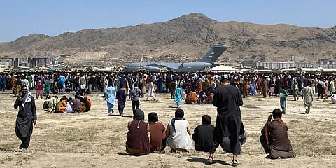 Hundreds of people gather near a U.S. Air Force C-17 transport plane at the perimeter of the international airport in Kabul, Afghanistan. (File Photo | AP)