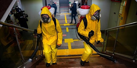 Employees of the Federal State Center for Special Risk Rescue Operations of Russia Emergency Situations disinfect the Savyolovsky railway station in Moscow. (Photo | AP)