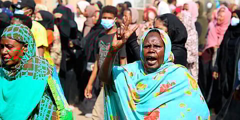 A pro-democracy protester flashes the victory sign as thousands take to the streets to condemn a takeover by military officials, in Khartoum, Sudan. (Photo | AP)