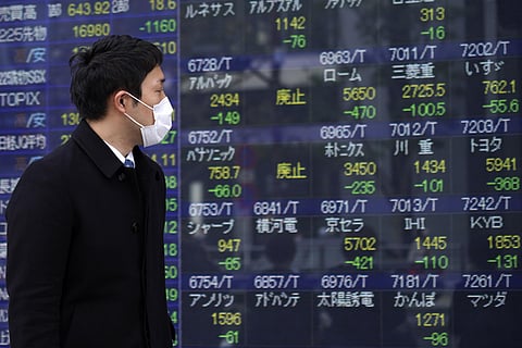 A man looks at an electronic stock board showing Japan's Nikkei 225 index at a securities firm in Tokyo. (File Photo | AP)