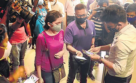 A theatre employee scans QR code on customer’s phone for contactless ticketing