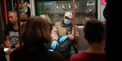 An elderly man wearing a face mask and gloves to protect against the coronavirus rides a subway car in Moscow, Russia. (Photo | AP)