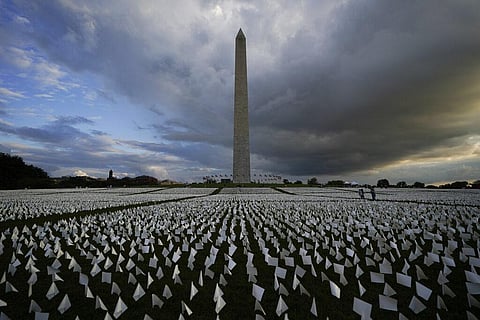 Washington Monument in the background, people look at white flags that are part of artist Suzanne Brennan Firstenberg's temporary art installation (Photo | AP)