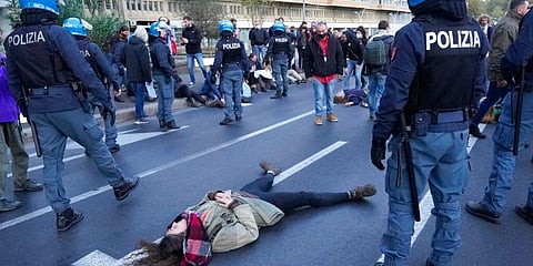 Climate activists try to block traffic in front of the Italian Ministry of the Ecological Transition on one of the main road leading to La Nuvola (the cloud) convention center. (Photo | AP)