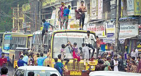 Youth climb a bus to celebrate Thevar pooja in Madurai. (Photo | Express)