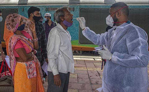 A health worker takes a swab sample of a traveler to test for COVID-19 at a train station in Mumbai, India, Thursday, Sept. 30, 2021. (Photo | AP)