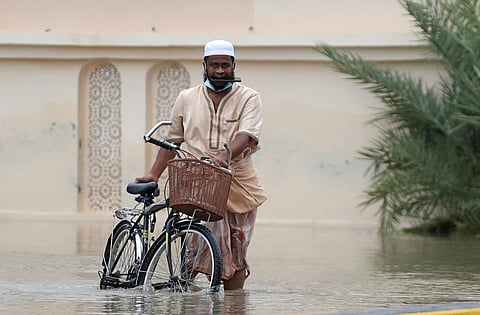 A man wades through a flooded street amid cyclone Shaheen in Oman's capital Muscat on October 3, 2021. (Photo | AFP)