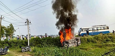 A vehicle set ablaze after violence broke out after farmers agitating were allegedly run over by a vehicle in the convoy of a union minister. (Photo | PTI)