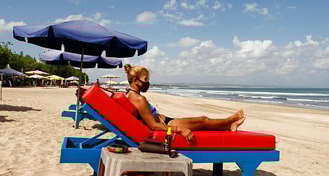 A tourist wearing face sunbathe as beaches are gradually reopening following months of lockdown due to the new coronavirus outbreak, in Bali, Indonesia. (Photo | AP)