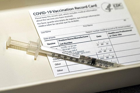 A syringe containing a dose of the Pfizer COVID-19 vaccine sits in a container. (File Photo | AP)