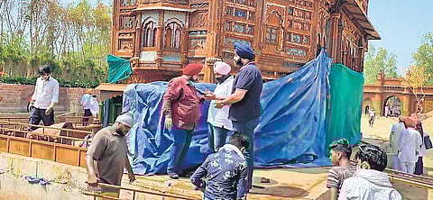 Gurudwara management committee members and municipal workers bring down the replica of Golden Temple at Bharat Darshan Park in Punjabi Bagh. (File photo| EPS)