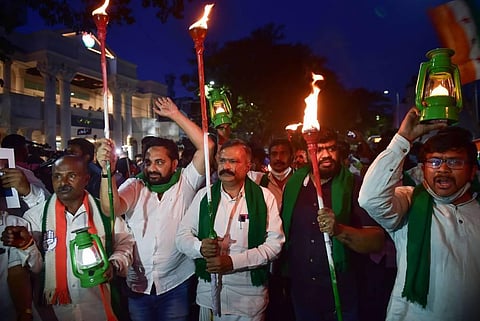 Congress workers hold torches and lanterns during a protest against the Lakhimpur Kheri incident, in Bengaluru, Monday, Oct. 4, 2021. (Photo | PTI)