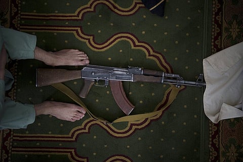 A Taliban fighter lays his AK-47 rifle down during Friday prayers at a Mosque in Kabul, Afghanistan, Friday, Sept. 10, 2021. (Photo | AP)