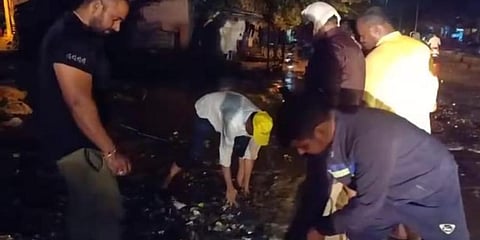 Mayor ST Veeresh cleaning the road to enable flow of water on PB Road in Davangere on Wednesday night. (Photo | Express)