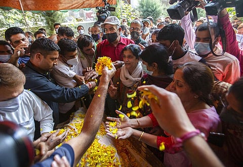 Relatives and neighbors offer flowers on the body of prominent pharmacist Makhan Lal Bindroo during his funeral in Srinagar. (Photo | AP)
