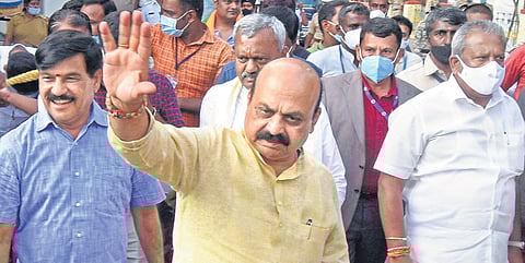 Chief Minister Basavaraj Bomai greets a gathering at the valedictory ceremony of Modi Yug Utsav in Mysuru on Wednesday. Minister Byrathi Basavaraj (extreme right) and MLA SA Ramadass look on | Uday