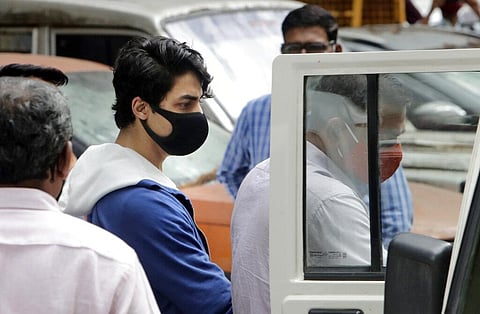 Aryan Khan, center, escorted by law enforcement officials from Narcotics Control Bureau office is being taken for a medical check up in Mumbai. (Photo | AP)