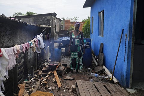 Lady Laurentino, 74, poses for a photo next a wood fire she uses to cook near the door of her home in the Jardim Gramacho favela of Rio de Janeiro, Brazil, Monday, Oct. 4. (Photo | AP)
