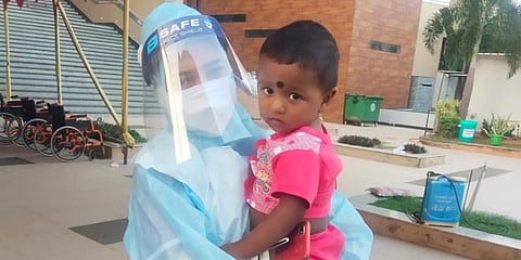 The baby boy with a healthcare worker at SUM Covid Hospital.