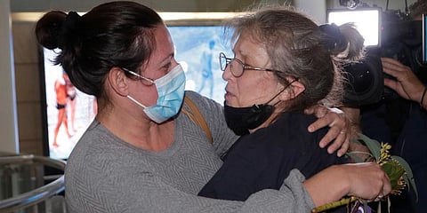 A woman (R) is embraced by. a loved-one after arriving on a flight from Los Angeles at Sydney Airport as Australia open its borders for the first time in 19 months in Sydney. (Photo | AP)