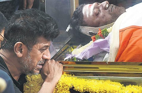 An inconsolable Shivarajkumar grieves next to his brother’s body at Kanteerava Stadium. (Photo | Ashishkrishna HP, EPS)