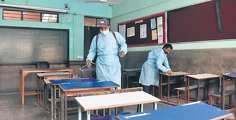 Workers disinfect a classroom before reopening of school | Parveen Negi