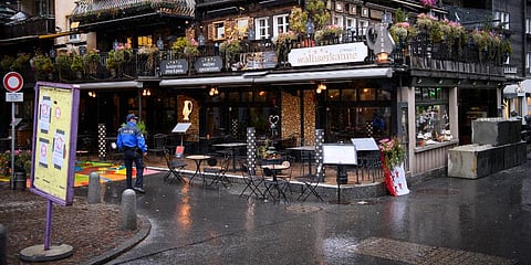 A police officer controls the presence of people at the restaurant 'Walliserkanne', in the mountain resort of Zermatt, Switzerland. (Photo | AP)