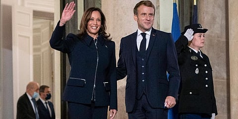 French President Emmanuel Macron stands next to Vice President Kamala Harris as she waves before a bilateral meeting at Élysée Palace in Paris, France. (Photo | AP)
