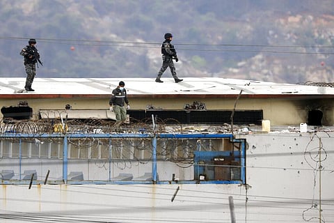 The body of a prisoner appears surrounded by police on the roof of the Litoral penitentiary the morning after riots broke out inside the jail in Guayaquil, Ecuador. (Photo | AP)