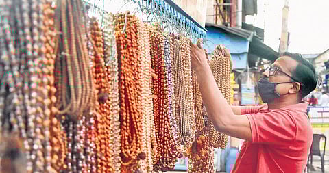 A vendor at Chalai market in Thiruv-ananthapuram arranges customary bead chains on Friday ahead of the Sabarimala pilgrimage season which starts on Tuesday. Traders are expecting good sales this year