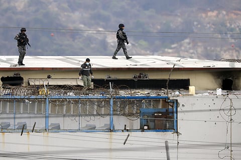 The body of a prisoner appears surrounded by police on the roof of the Litoral penitentiary the morning after riots broke out inside the jail in Guayaquil, Ecuador, Saturday, Nov. 13, 2021. (AP)