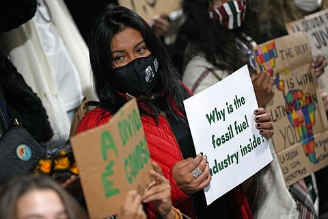 Youth climate activists protest that representatives of the fossil fuel industry have been allowed inside the venue during the COP26 U.N. Climate Summit. (Photo | AP)