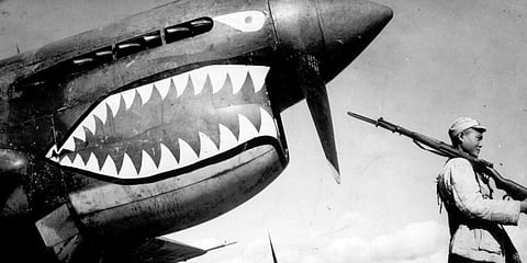 Guarded by a Chinese soldier, a squadron of Curtiss P-40 fighter planes, decorated with the typical shark face of the famed Flying Tigers, are lined up at an airbase in China in 1943. (Photo | AP)