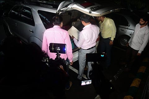 ACB officials taking away documents from the BDA office in their vehicles.