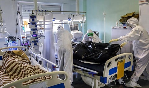 Medics wearing special suits to protect against coronavirus prepare to transport the body of a COVID-19 victim at an ICU of a hospital in Russia (Photo | AP)