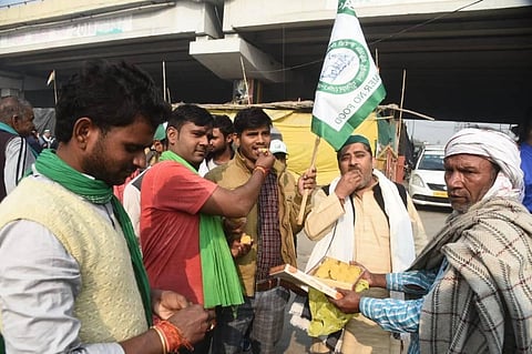 Farmers celebrating and distribute sweets after PM Modi decided to repeal all three farm laws, at Ghazipur border in New Delhi on Friday. (Photo | Parveen Negi, EPS)