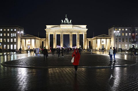 People gather in front of Germany landmark the Brandenburg Gate in Berlin, Germany, Thursday, Nov. 18, 2021. (Photo | AP)