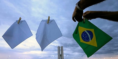 White scarves representing people who have died of COVID-19 in Brazil are hung over a field to protest the government's health policies outside Congress in Brasilia. (Photo | AP)