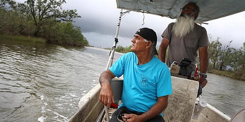 Donald Dardar, left, and Russell Dardar look toward the eroding shoreline of Bayou Pointe-au-Chien in southern Louisiana. (Photo | AP)
