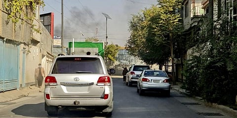 Vehicles move along a road against the backdrop of smoke rising from the site of blast in Kabul after Afghanistan's capital was hit by two blasts near a military hospital. (Photo | AFP)