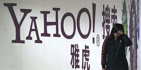 A woman walks past a Yahoo billboard in a Beijing subway. (Photo | AP)