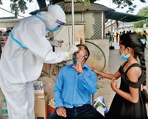 A health worker collects throat swab in Bengaluru | Express